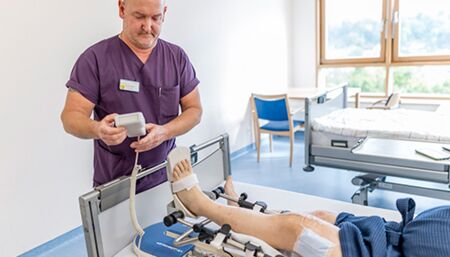 Physiotherapeut bei Patienten nach Knie-OP.