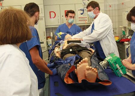 Ärzte und Pfleger mit Simulationspuppe im Schockraum